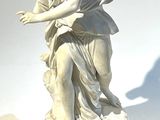 une statue représentant une femme tenant un oiseau, posée sur un socle