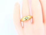 yellow gold ring with a diamond on the middle of it ' s finger