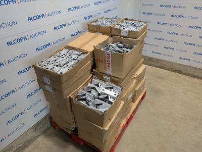 Plusieurs cartons contenant des pièces métalliques diverses sont empilés sur une palette
