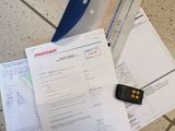 a knife and some papers on the floor next to a remote