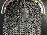 a silver purse with a chainmail clasp on it