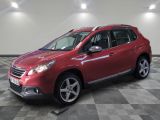 la voiture rouge est garée sur un sol en damier dans le garage