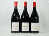 trois bouteilles de vin rouge sont alignées sur une surface blanche