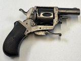 un petit pistolet posé sur une surface blanche
