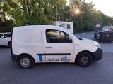 a white van parked in a parking lot with trees in the background