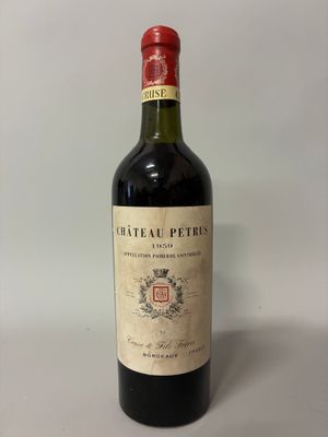 une vieille bouteille de vin posée sur une table blanche