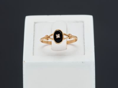 a close up of a gold ring with a black stone