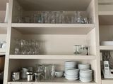 de nombreux plats et verres sur les étagères de la cuisine
