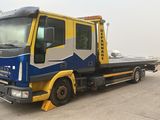 a blue and yellow tow truck parked in a parking lot