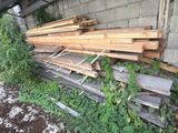 a pile of wood sitting on the ground next to a building