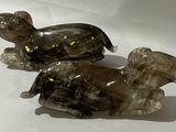 deux figurines en verre représentant des éléphants assis sur une surface blanche
