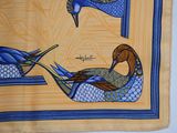 two birds that are sitting on a yellow cloth