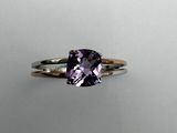 a close up of a ring with a purple stone on it