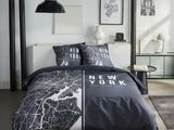 grey and white bedding with a map of new york printed on it