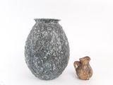 a vase and a small figurine sitting next to each other