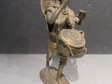 bronze figurine of a boy with a drum and a basket