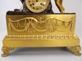 a gold clock sitting on top of a table