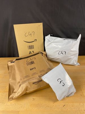 three bags of food sitting on top of a wooden table next to a cardboard box
