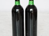 two bottles of wine sitting on top of a marble counter top