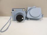 a blue camera with a blue case on the table