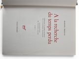 an open book with red writing on it sitting on a white surface