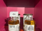 deux bouteilles d'alcool sont posées sur une étagère, dans une boîte rose