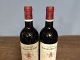 two bottles of wine sitting on a table next to each other