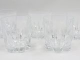 six verres sont alignés sur une surface blanche