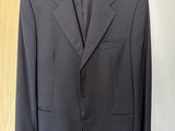 a suit hanging on a hanger in front of a wooden door