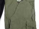 two pairs of green pants sitting on top of a white surface