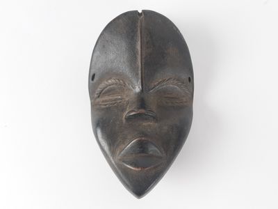 an image of a wooden mask hanging on a wall
