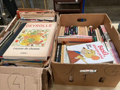de nombreux livres dans une boîte en carton posée sur le sol