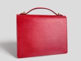 a red louis vuitton briefcase bag on a grey background