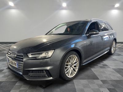 a grey audi is parked on a checkered floor in a garage