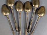 five spoons are sitting next to each other on a table