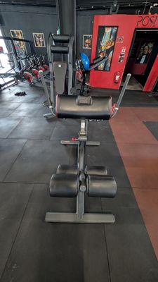 a gym room with a row of exercise equipment in it