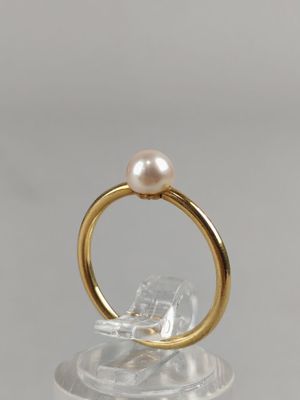 a close up of a gold ring with a pearl on top of it