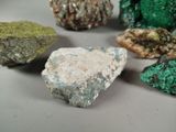 several different colored rocks are arranged on a white surface