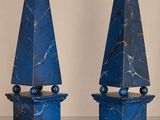 une paire d'obélisques en marbre bleu posés sur une table, sur fond blanc