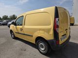 yellow van parked in a parking lot with other cars in the background