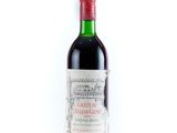 une bouteille de vin rouge posée sur une table blanche