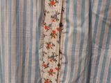 a close up of a blue and white striped shirt with a floral design