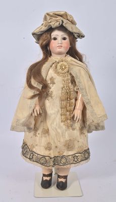 an antique doll of a woman with long hair wearing a dress and hat