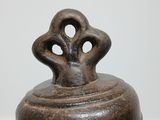 a large metal bell sitting on top of a wooden table