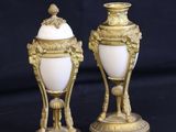 pair of antique gold and white vases on a black background