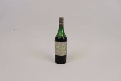 une vieille bouteille de vin posée sur une surface blanche