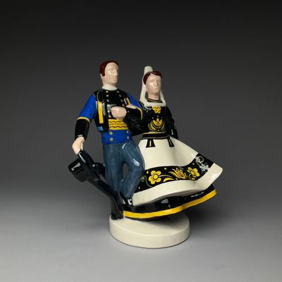 figurine of a man and a woman sitting on top of a chair