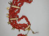 un collier de perles rouges orné d'un dragon en or