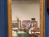 a mirror sitting on a table in front of a blue curtain