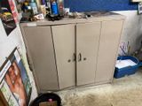 un chien assis par terre devant une armoire